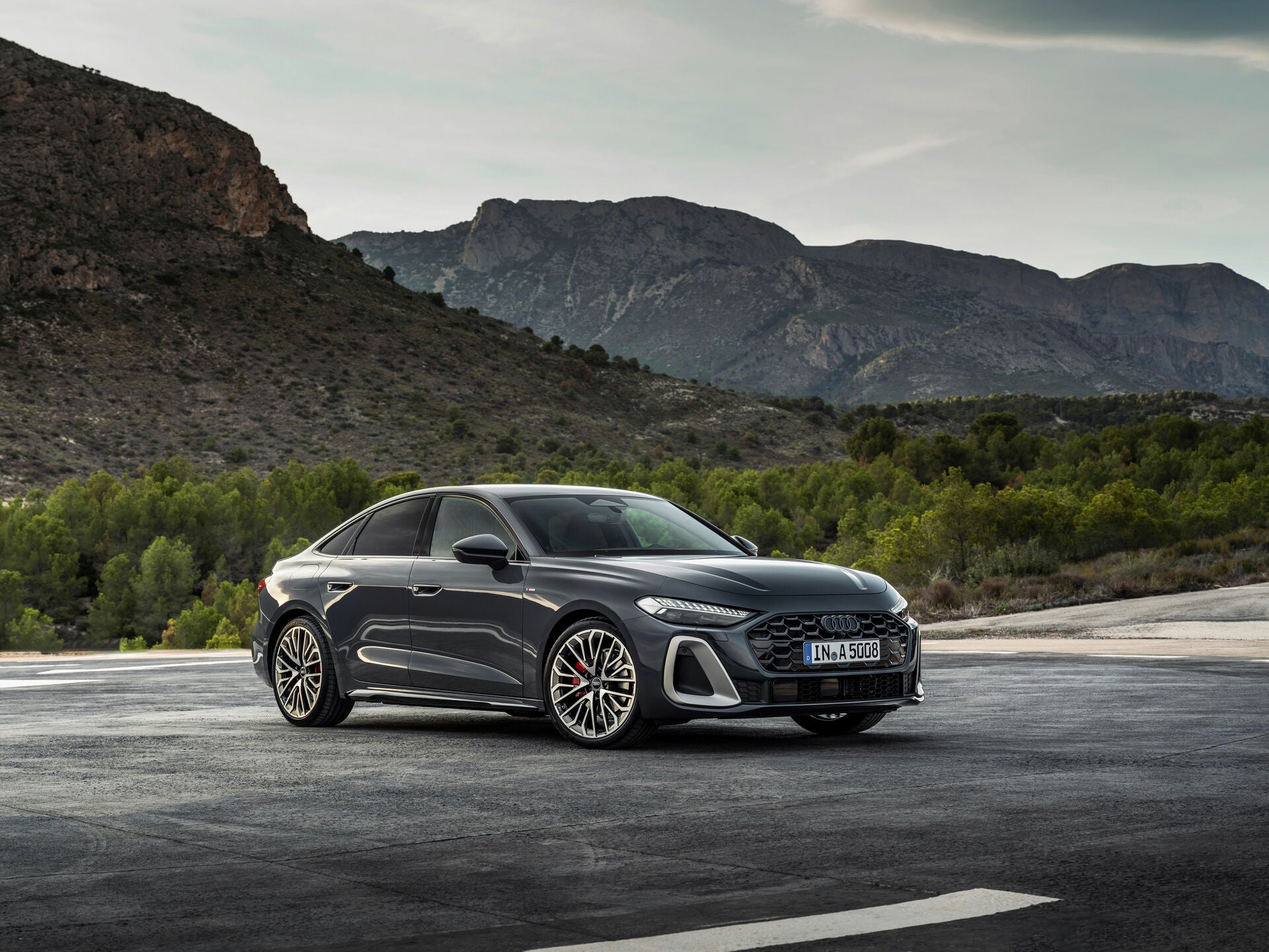 2025 Audi A5 sedan parked in front of a large mountains